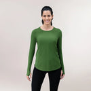 A model in a dark green Twirl top with long sleeves over black leggings - عارضة أزياء ترتدي بلوزة "تويرل" طويلة الأكمام باللون أخضر غامق مع ليقنز أسود