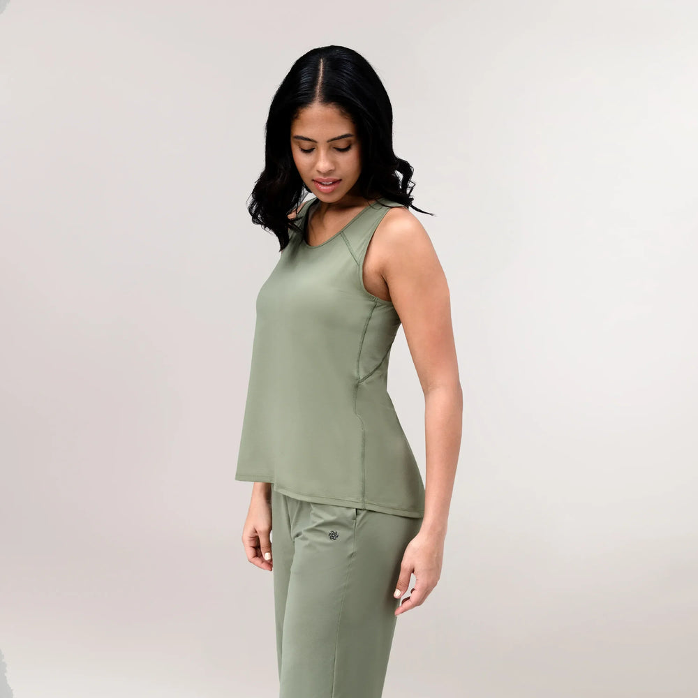 A model wearing a core musk green Flow racerback top over matching pants - عارضة أزياء ترتدي بلوزة رياضية "فلو" باللون الأخضر مع بنطال متناسق