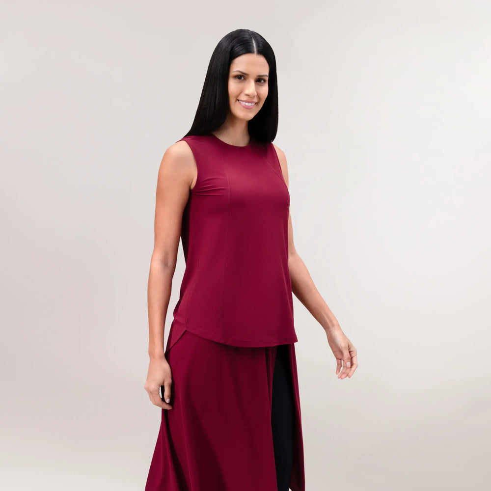 A model wearing core grape red Twirl sleeveless top - عارضة أزياء ترتدي بلوزة "تويرل"حمراء اللون بدون أكمام وبقصة دائرية