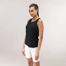 A model wearing a core black "Limber Up" tank over white shorts - عارضة أزياء ترتدي توب أسود فضفاض بتصميم "ليمبر آب" فوق شورت أبيض