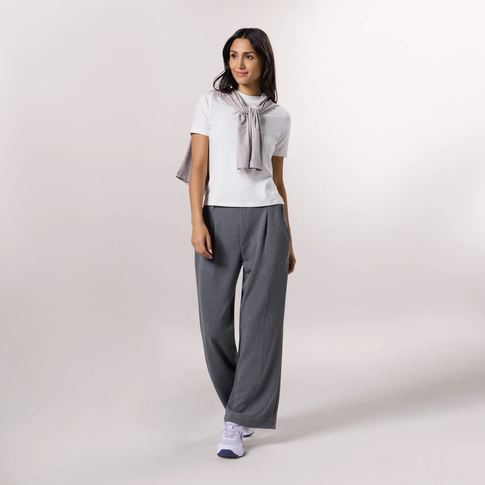 A model wearing seasonal white elevated t-shirt over grey pants - عارضة أزياء ترتدي تيشيرت أبيض مع بنطال رمادي