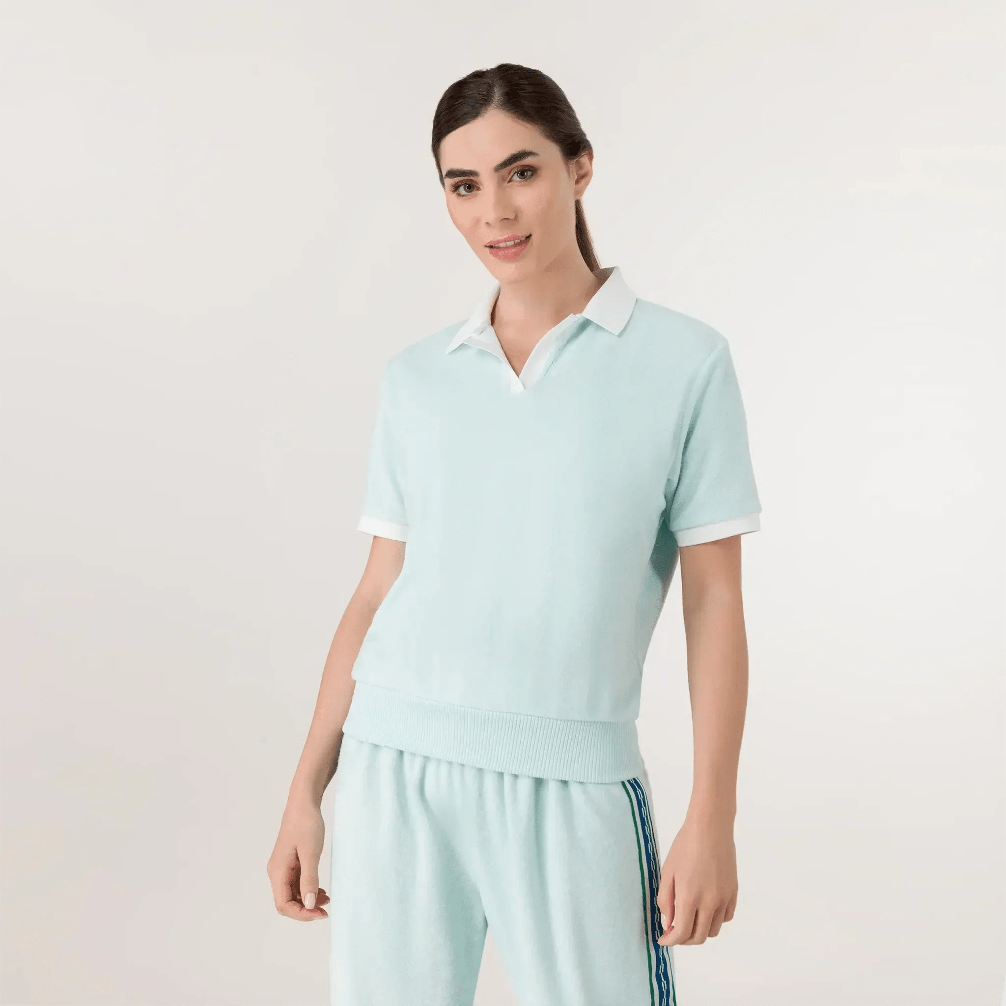 A model wearing a seasonal light blue velour polo tee - عارضة أزياء ترتدي تيشيرت بولو باللون الأزرق الفاتح