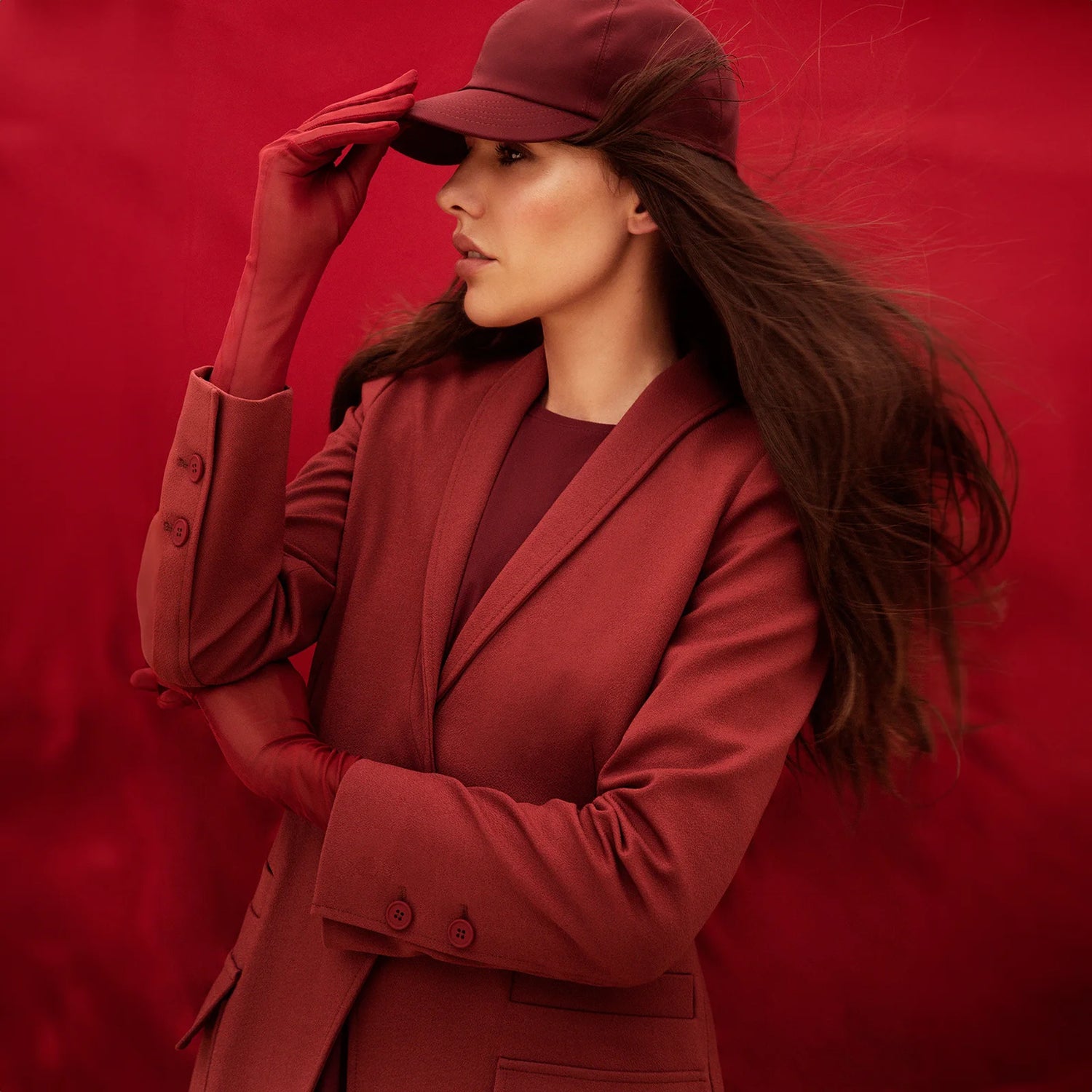 A woman wearing a red jacket and matching sport hat from Kayanee KSA