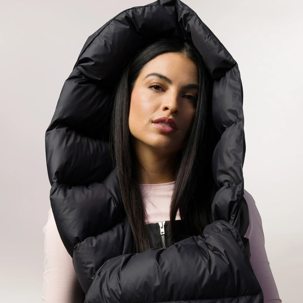 A model wearing a hooded seasonal black down stole - عارضة أزياء ترتدي سترة باللون الأسود الموسمي مع غطاء رأس