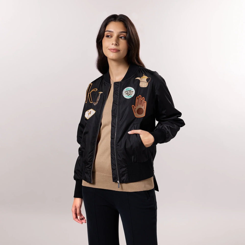 A model in seasonal black bomber jackets with trendy badges - عارضة أزياء ترتدي سترة سوداء ذات شارات عصرية