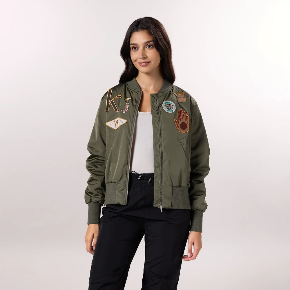 A model wearing seasonal olive bomber jacket with trendy badges - عارضة أزياء ترتدي سترة باللون الزيتي ذات شارات عصرية