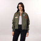 A model wearing seasonal olive bomber jacket with trendy badges - عارضة أزياء ترتدي سترة باللون الزيتي ذات شارات عصرية