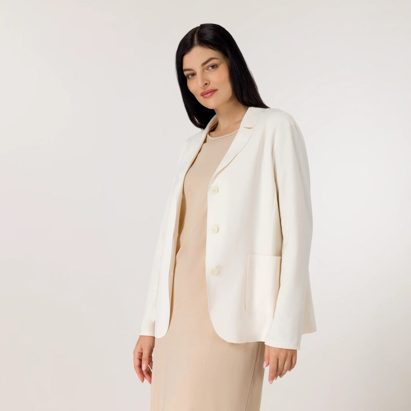 A model wearing a seasonal ivory light blazer over plain dress - عارضة أزياء ترتدي بليزر خفيف باللون العاجي فوق فستان سادة