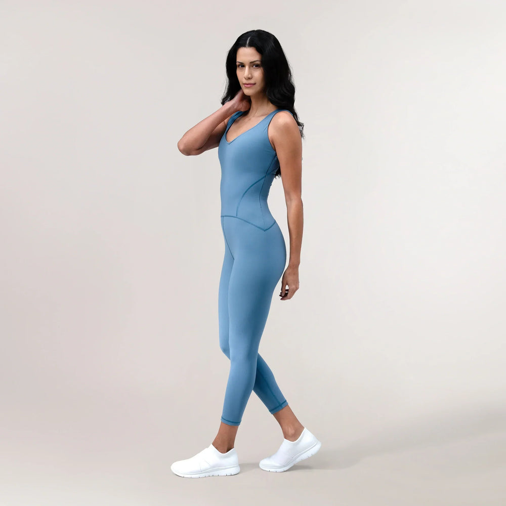 A model wearing a core blue sculpting unitard - عارضة أزياء ترتدي بدلة محبوكة باللون الأزرق