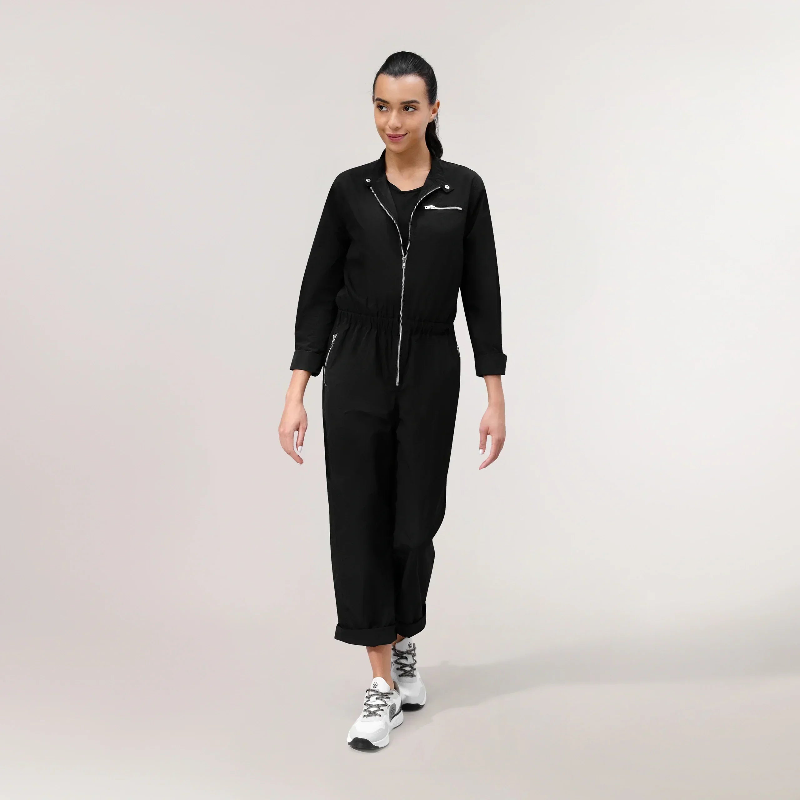 A model in a seasonal black parachute jumpsuit with a side pocket - عارضة أزياء ترتدي طقم رياضي براشوت أسود مع جيب جانبي