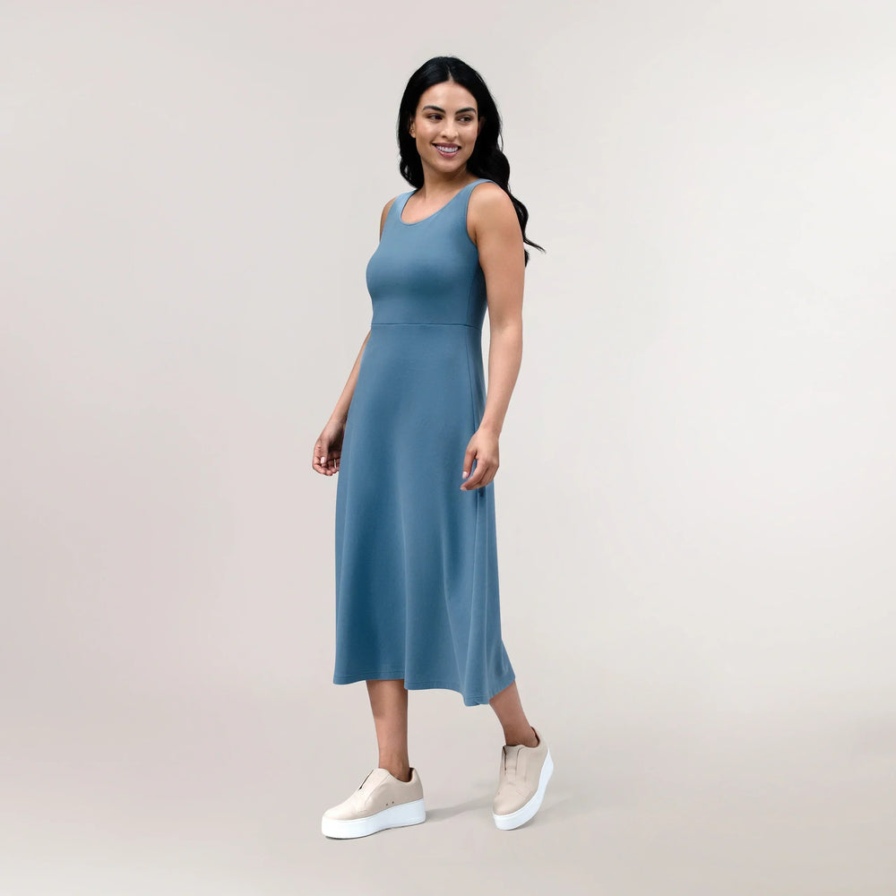 A model wearing a sleeveless walkabout jersey dress in a core blue color - عارضة أزياء ترتدي فستان أزرق بدون أكمام مصنوع من القماش الجيرسي
