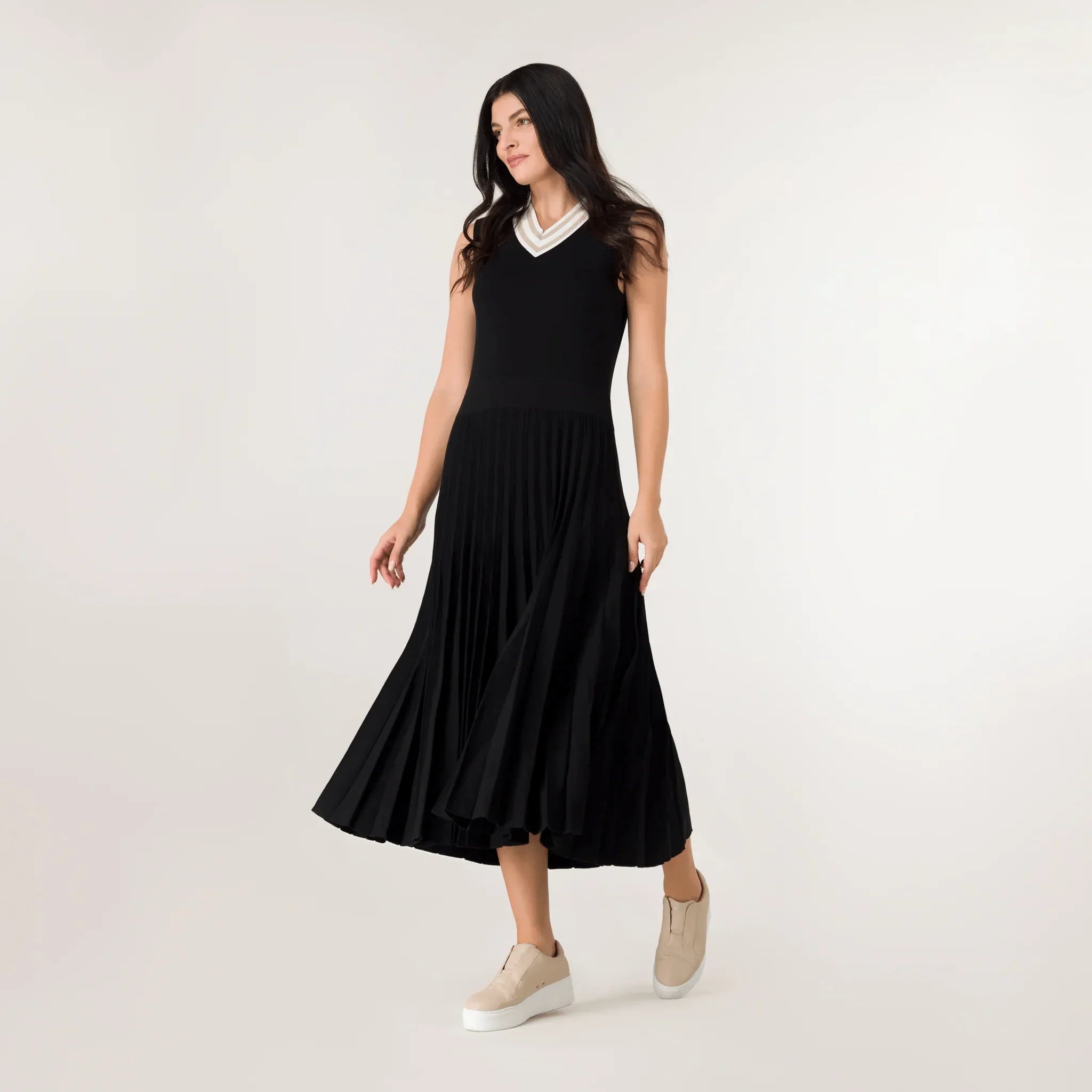 A model wearing a sleeveless pleated knit dress in a seasonal black color - عارضة أزياء ترتدي فستان أسود محبوك بدون أكمام