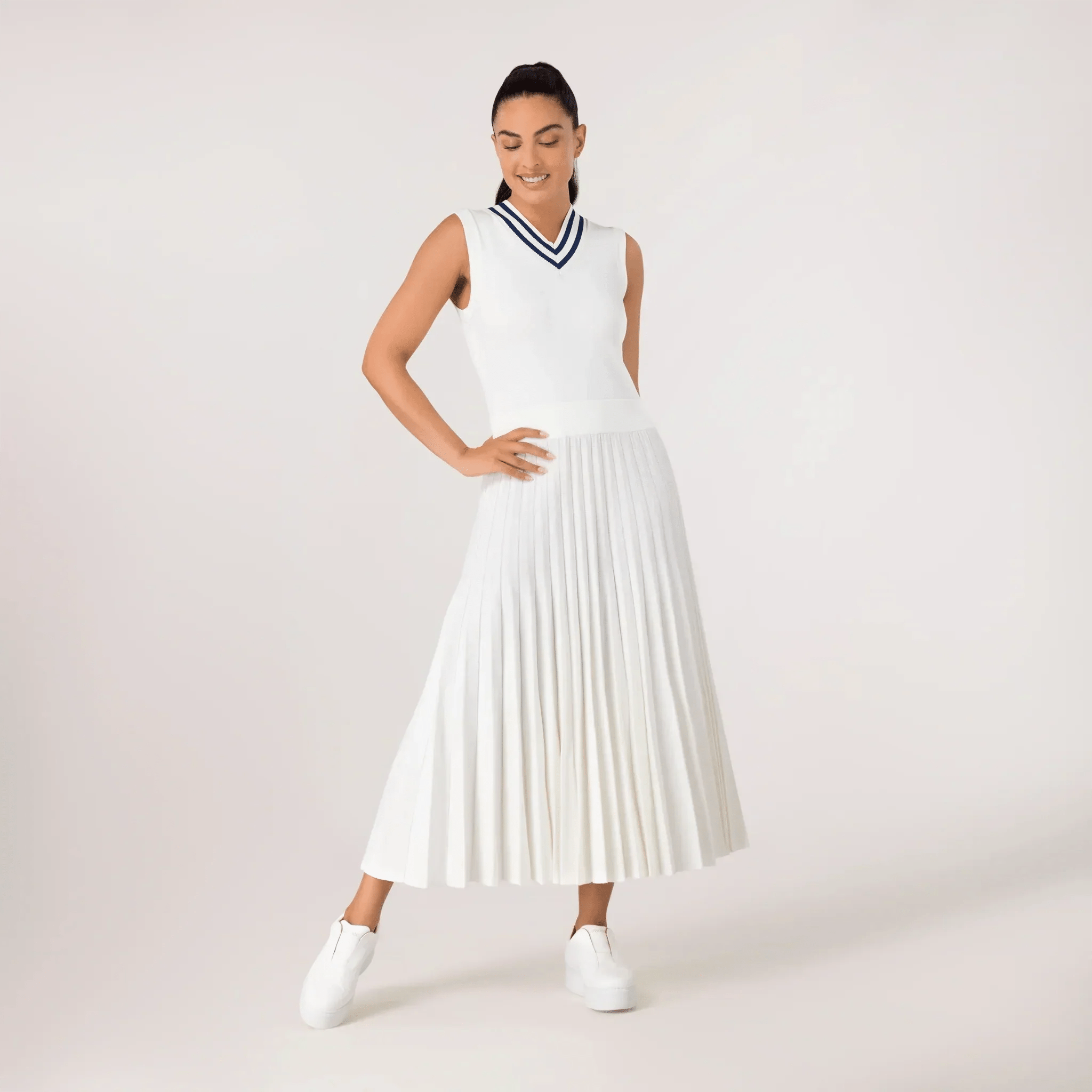 A model wearing sleeveless pleated knit dress in a seasonal white color - عارضة أزياء ترتدي فستان أبيض محبوك بدون أكمام