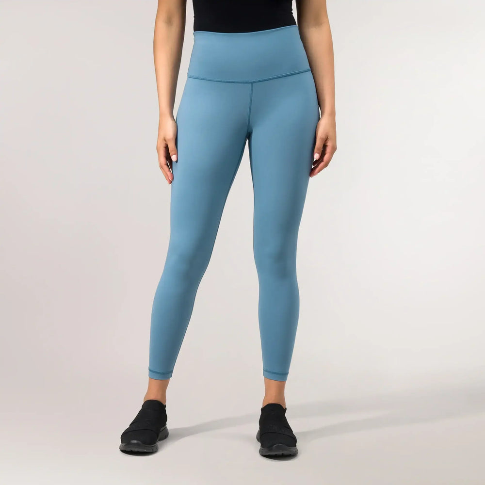 A model wearing blue compression crop leggings with sculpting fit - عارضة أزياء ترتدي ليغينغ قصير ضاغط باللون الأزرق بقصة تنحت القوام