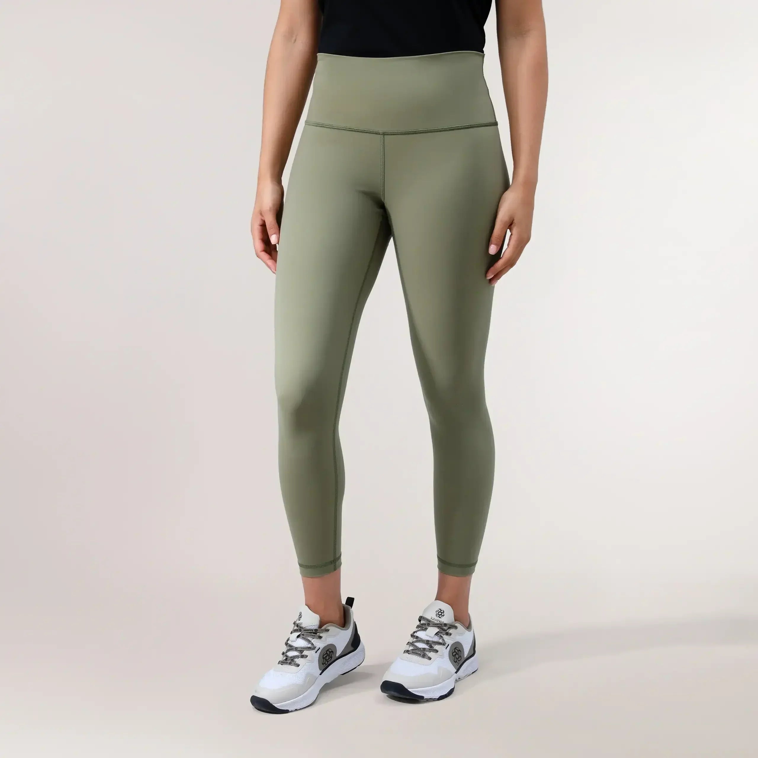 Musk green sculpting compression leggings with high-rise waist & sleek finish - عارضة أزياء ترتدي ليقنز ضاغط أخضر بخصر عالٍ