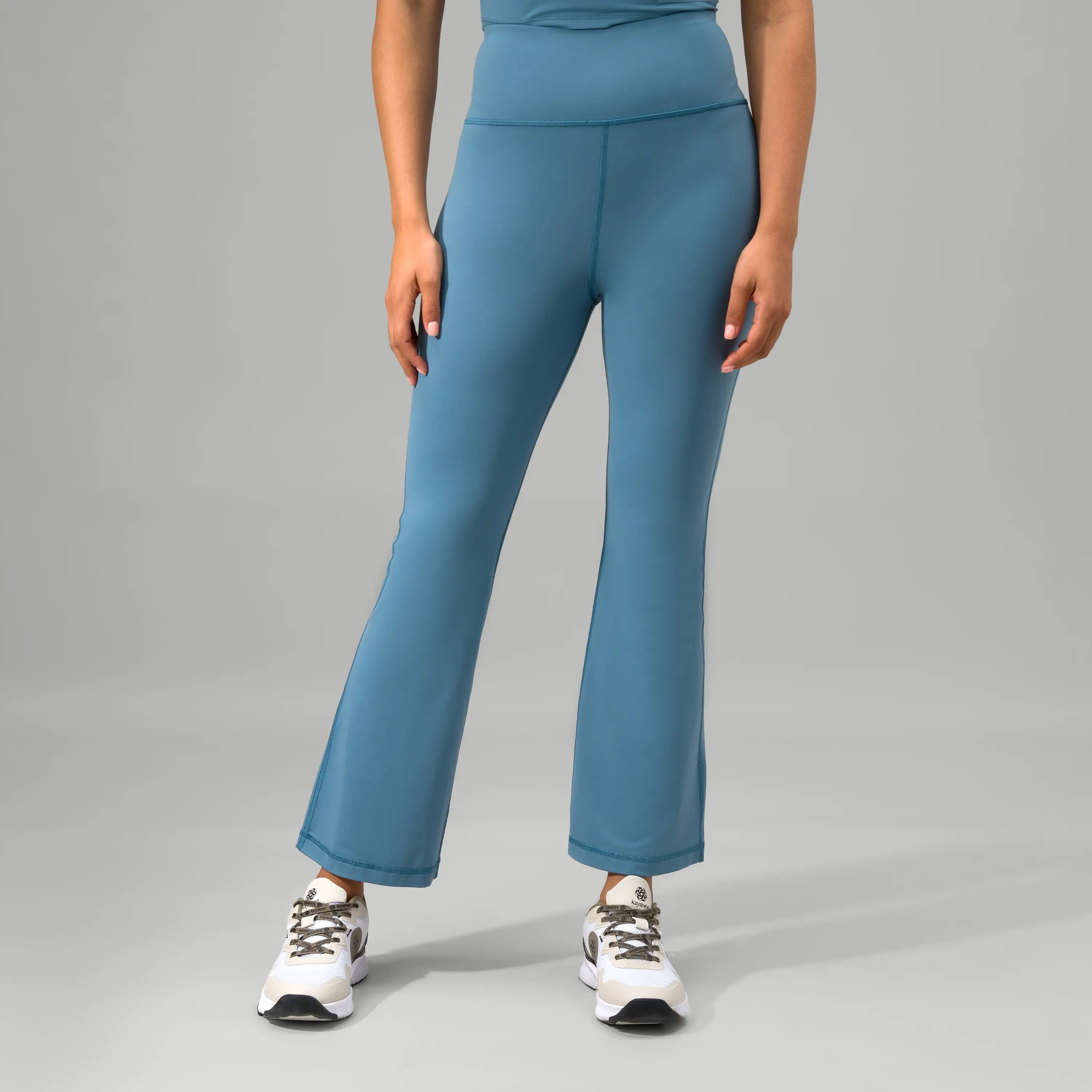 A model wearing flared blue jazz pants with a smooth stretch waistband - عارضة أزياء ترتدي بنطال جاز أزرق واسع مع حزام خصر مطاطي ناعم