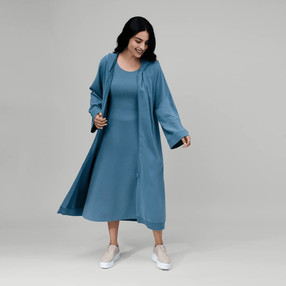 Front view of model wearing matching blue abaya and sleeveless dress set - منظر أمامي لعارضة أزياء ترتدي عباءة زرقاء فوق فستان بدون أكمام متناسق معها