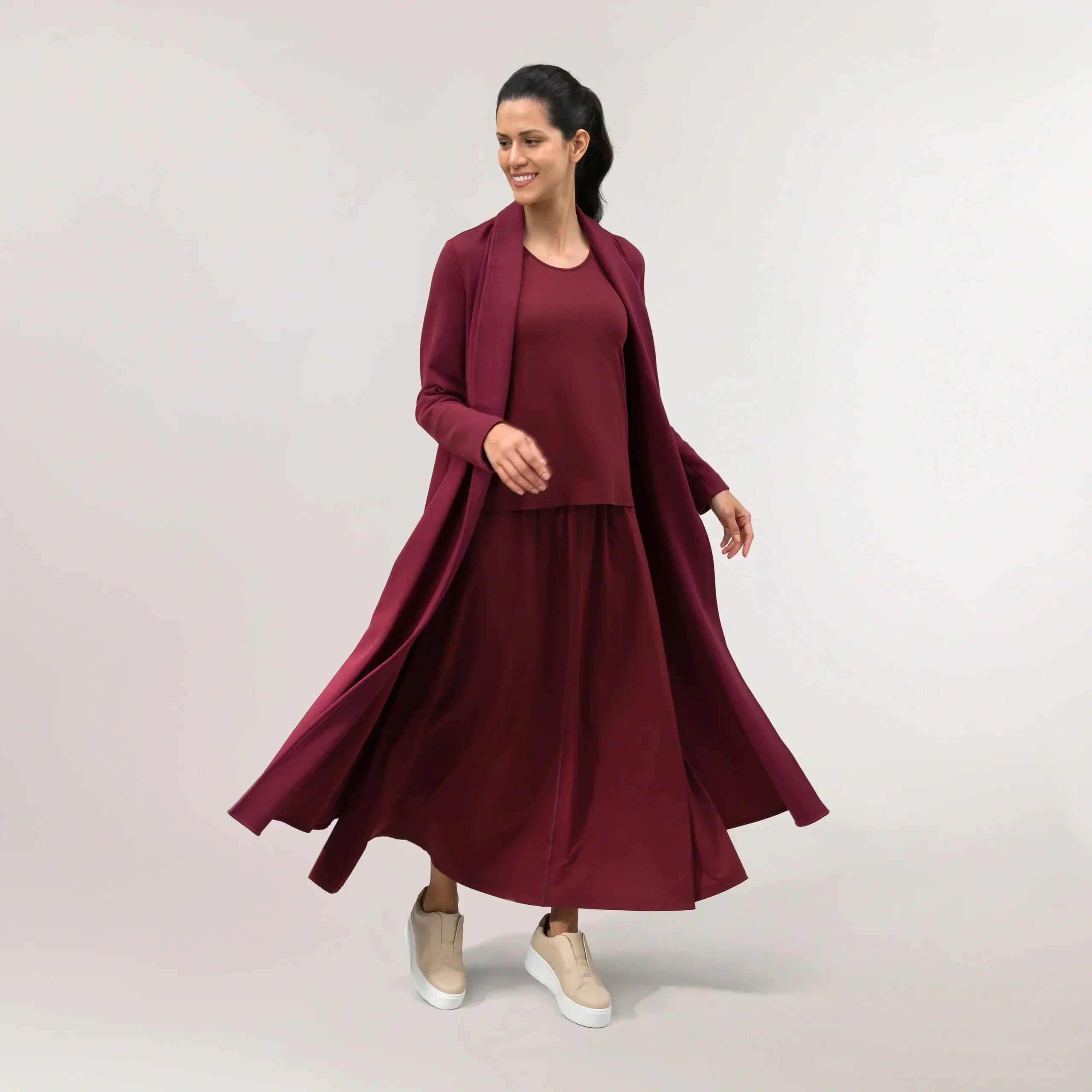 Grape red weekday abaya with soft drape & modest silhouette - عارضة أزياء ترتدي عباية يومية باللون الأحمر العنبي بانسيابية ناعمة وتصميم محتشم