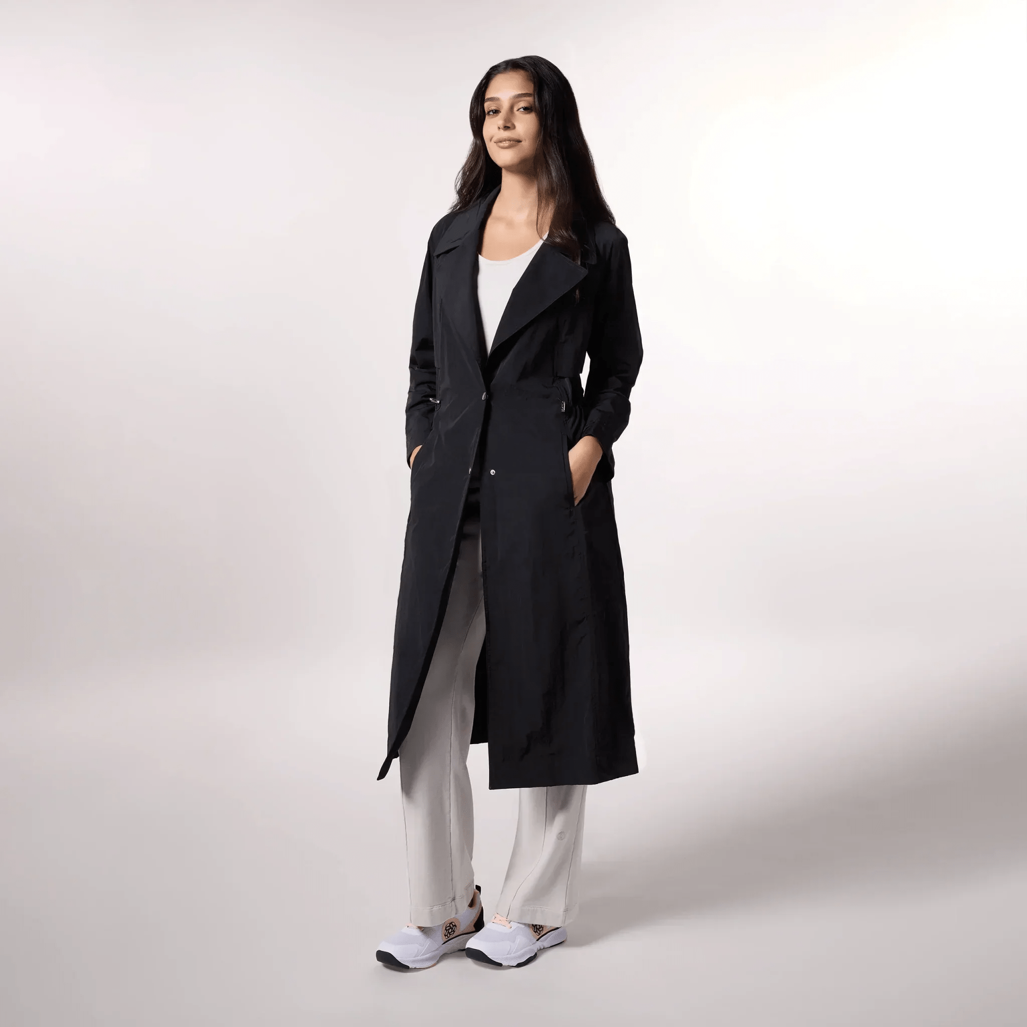 Black lightweight trench coat with belt detail & classic longline fit - عارضة أزياء ترتدي ترنش أسود خفيف بحزام وتصميم طويل كلاسيكي