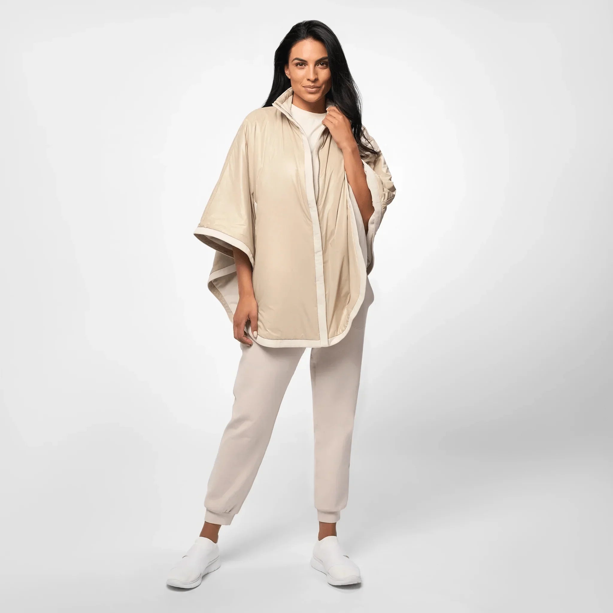 A model wearing reversible cape in core stone color - عارضة أزياء ترتدي جاكيت بوجهين باللون الحجري