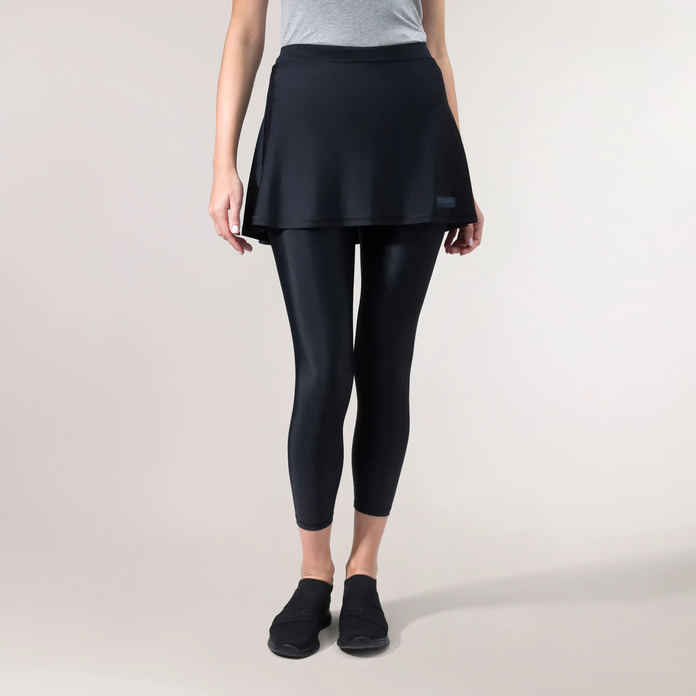 A model wearing core black dance leggings with attached skirt - عارضة أزياء ترتدي بنطال رقص أسود مع تنورة متصلة