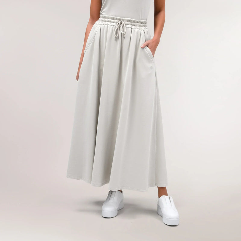 A model wearing core stone skirt with pockets - عارضة أزياء ترتدي تنورة باللون الحجري مع جيوب