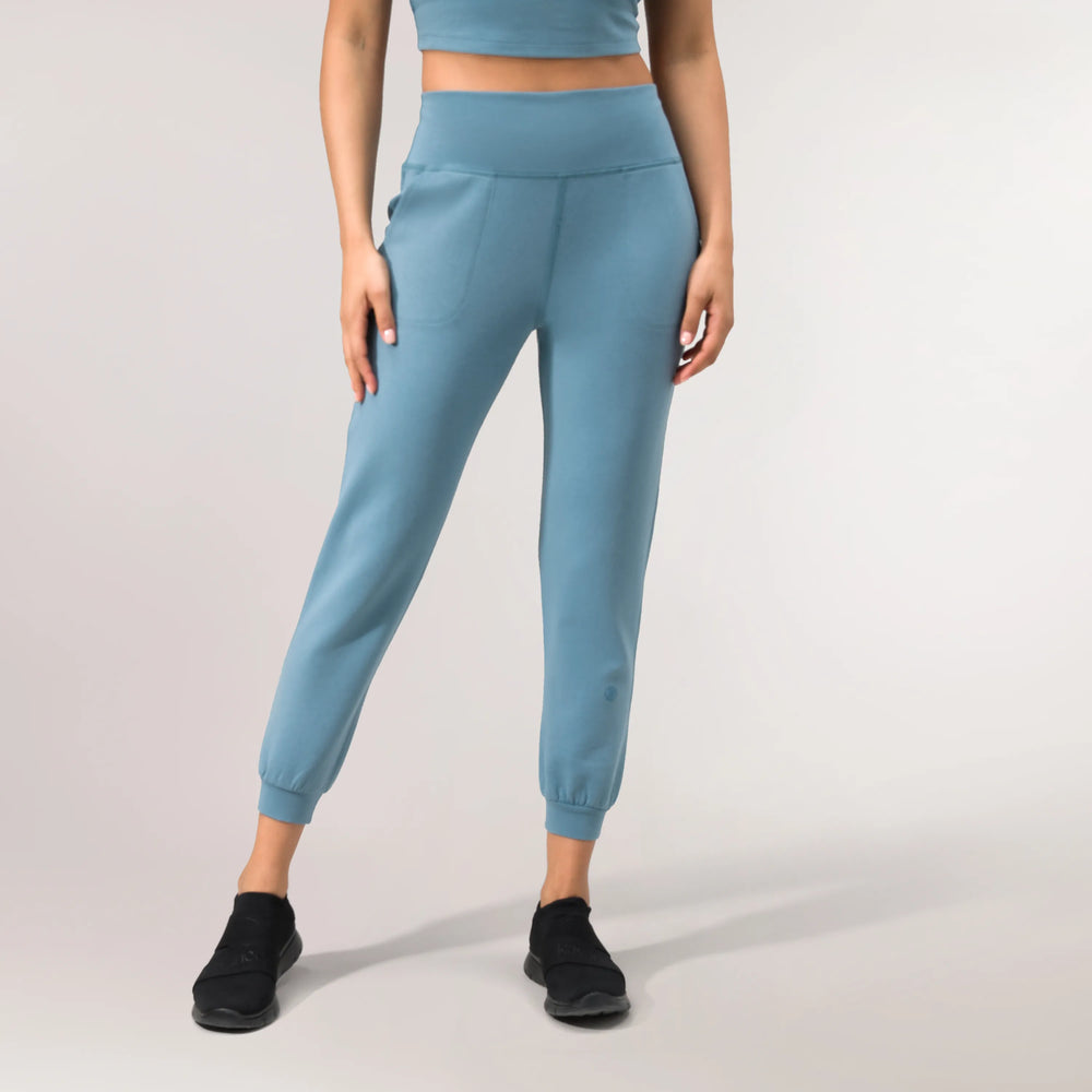A model wearing a core blue walkabout jogger with pockets - عارضة أزياء ترتدي بنطال رياضي مع جيوب باللون الأزرق