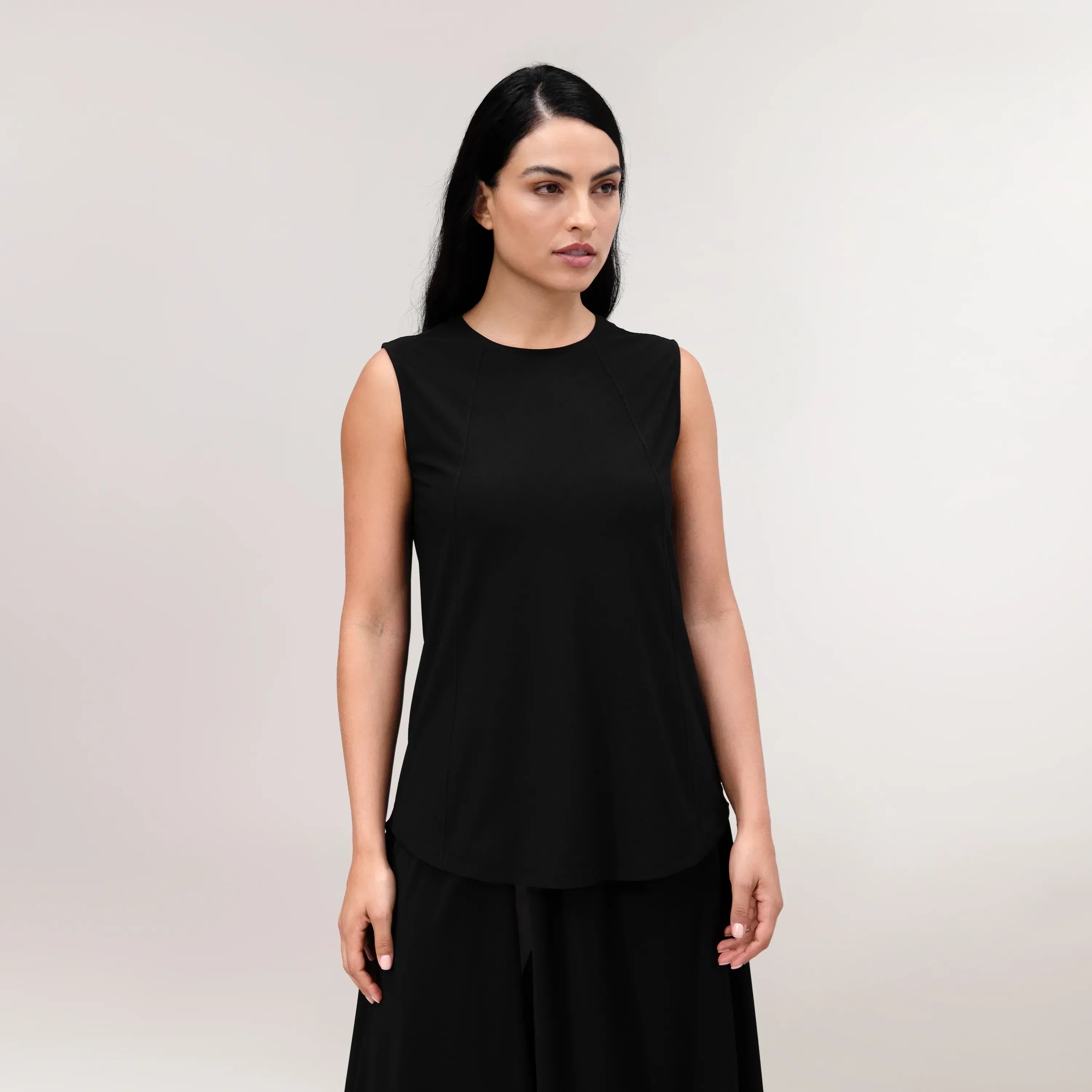 A model wearing core black Twirl tank top over skirt - عارضة أزياء ترتدي تانك توب "تويرل" أسود اللون مع تنورة