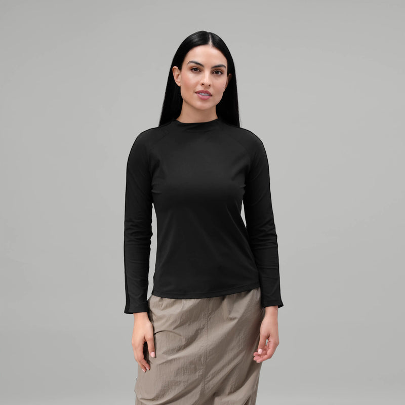 A model wearing a core black tee with long sleeves over a skirt - عارضة أزياء ترتدي تيشيرت أسود بأكمام طويلة فوق تنورة