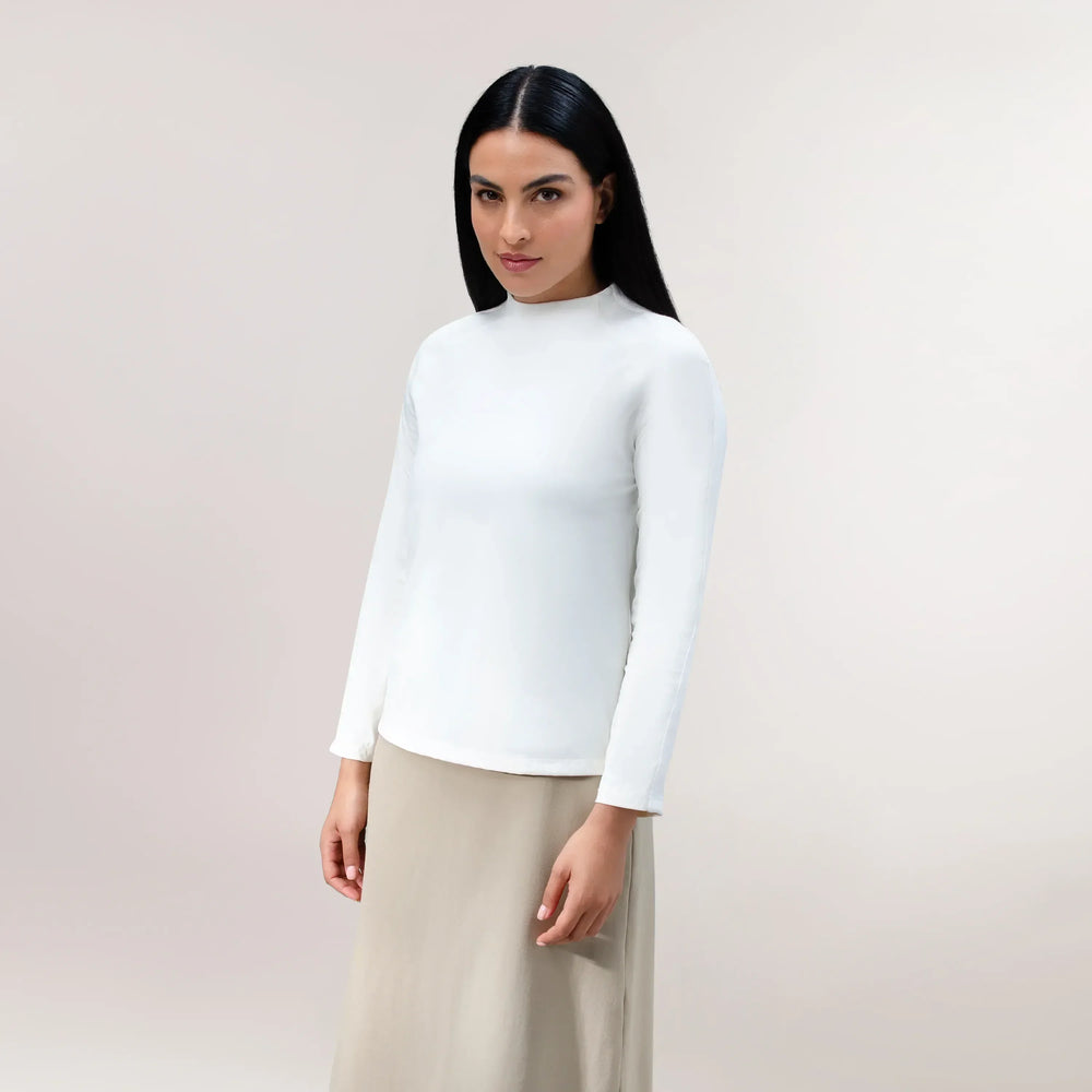 A model wearing a soft white long-sleeve tee with a relaxed seasonal fit - عارضة أزياء ترتدي تيشيرت أبيض ناعم بأكمام طويلة وقصّة موسمية مريحة