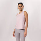 A model wearing a light pink racerback active top with a sleek fit - عارضة أزياء ترتدي توب رياضي باللون الوردي الفاتح وقصة أنيقة