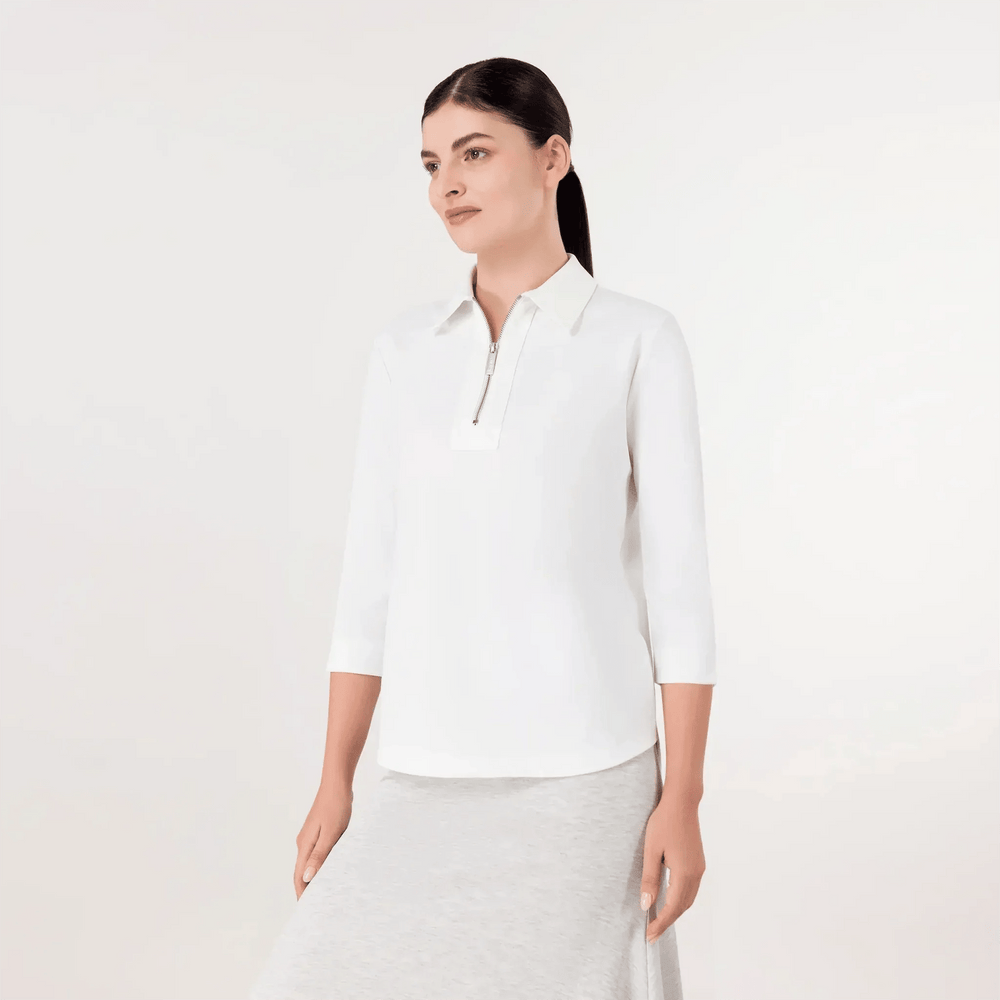A model wearing seasonal white half-zip polo top - عارضة أزياء ترتدي قميص بولو أبيض بنصف سحاب