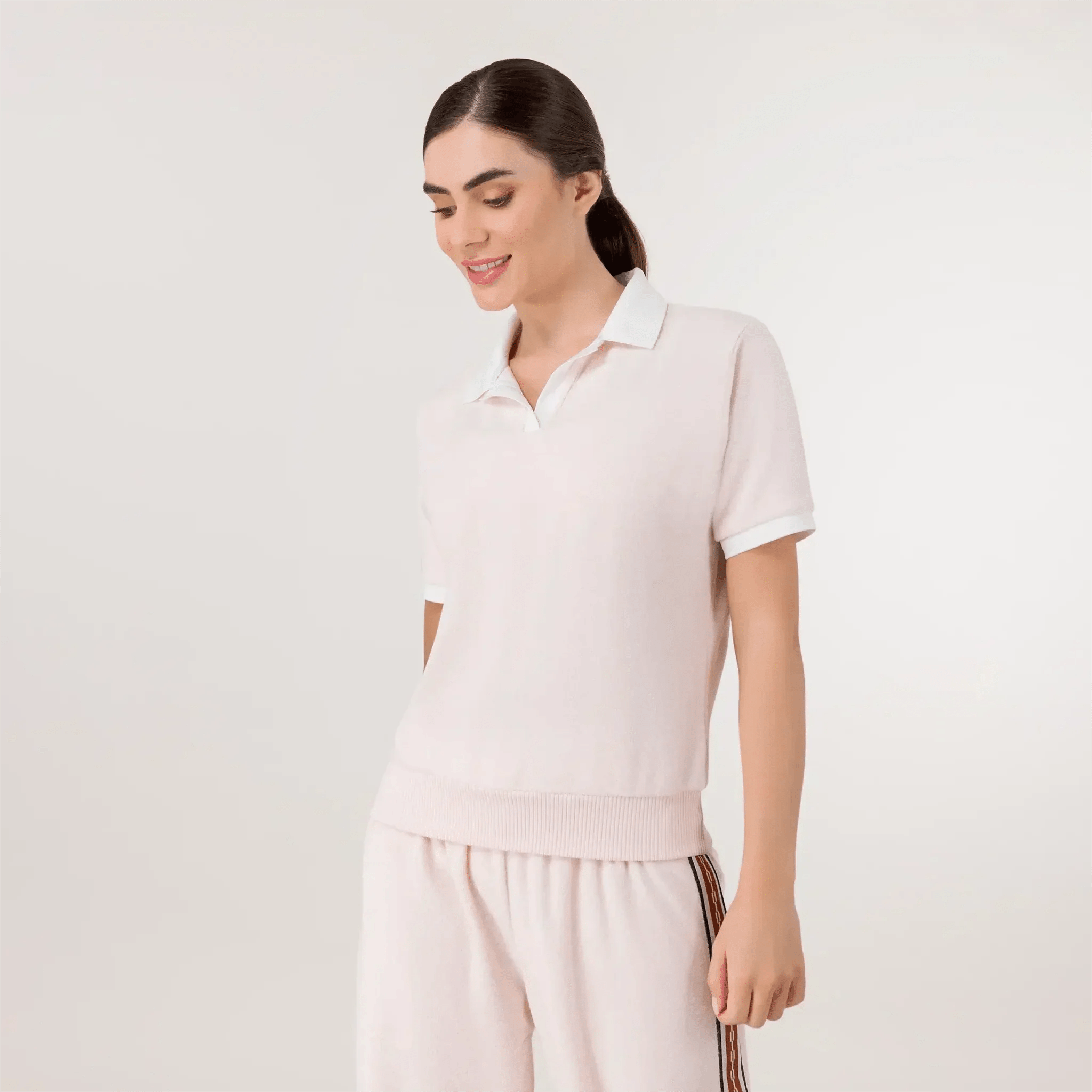 Pink Velour polo top with soft texture & button-up neckline - عارضة أزياء ترتدي توب بولو باللون الوردي من القماش الناعم وياقة بأزرار